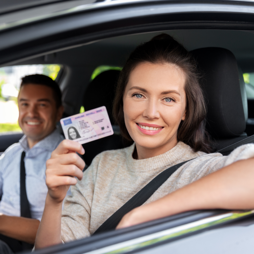 kobieta za kierownicą samochodu trzyma prawo jazdy Tłumaczenia przysięgłe w Poznaniu - dogadamycie.pl